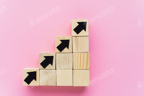 Preview: top view of wooden blocks with black arrows on pink background, business concept