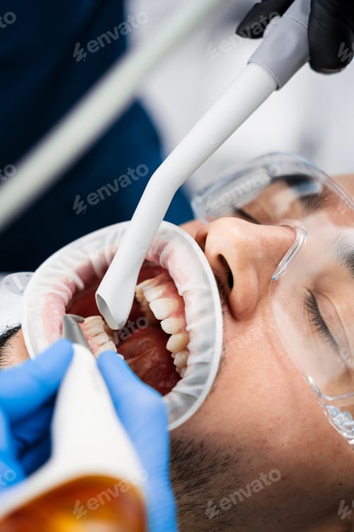 Vista previa: Dentist polishes teeth enamel using airflow instrument