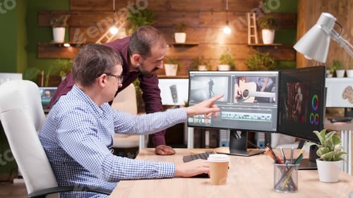 Preview: Videographer producer editing film production discussing movie graphic with photographer