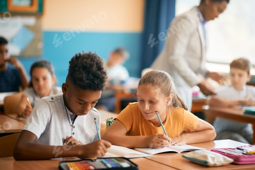 Preview: Elementary students writing and learning during a class in the classroom.