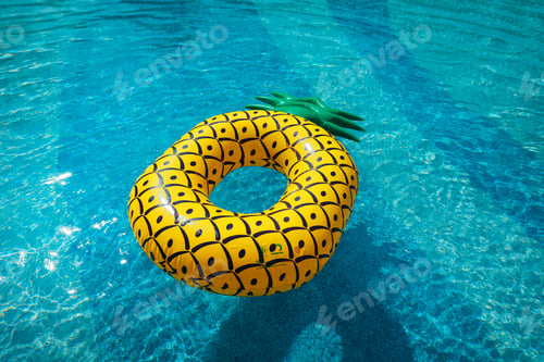 Preview: Yellow rubber ring floating in a blue pond on a summer day