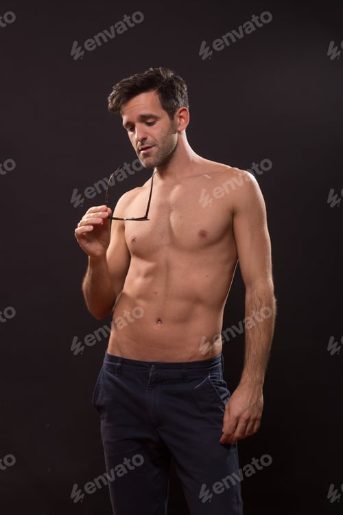 Preview: Young Man Posing Looking At Sunglasses Black Background Shirtless Abs Fit Slim