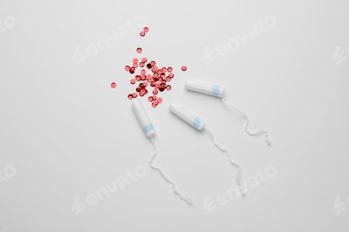 Preview: Tampons and red sequins on white background, flat lay. Menstrual hygiene product