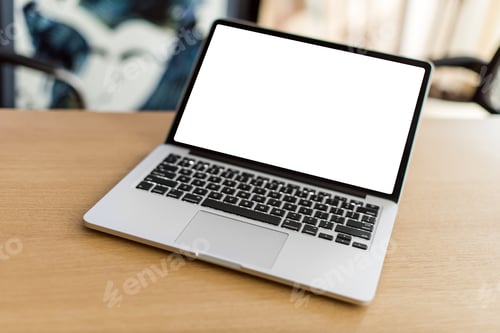 Preview: Laptop with blank screen on wooden table and blurred background