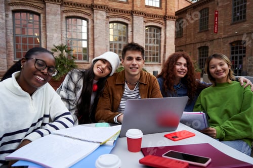 Preview: Portrait of a group of students looking at camera outside at university campus studying together.