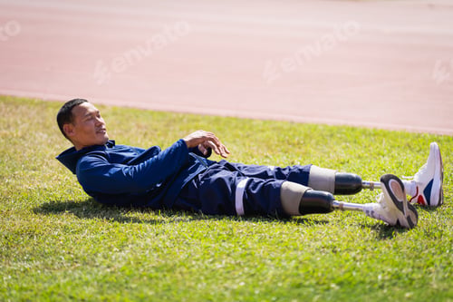 Vista previa: Asian para-athletes with prosthetic blades sprint on a running track at stadium.