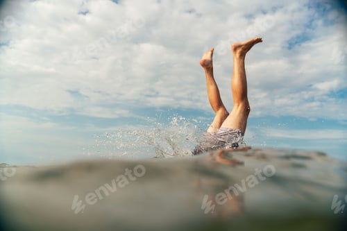 Preview: Man diving into the sea with half of his body in the water