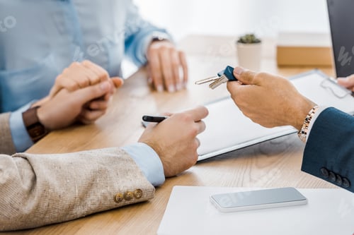 Preview: man holding keys while couple holding hands together