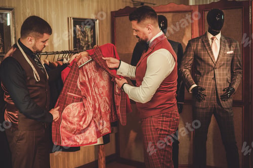 Preview: Tailor measuring client for custom made suit tailoring.