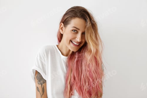 Preview: Young female model with attractive appearance and long wavy hair, looking shyly into camera, showing