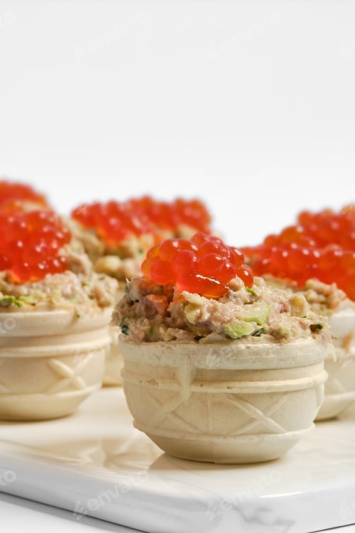 Preview: Delicious tuna tartlets topped with bright red caviar served at a stylish gathering