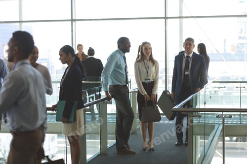 Preview: Front view of smiling diverse business executives interacting with each other in office lobby