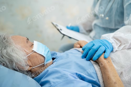 Preview: Senior Patient Lying in Hospital Bed With Caregiver