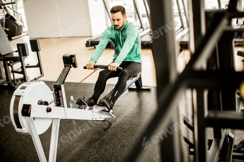 Preview: Young man exercise on an exercise machine at the gym
