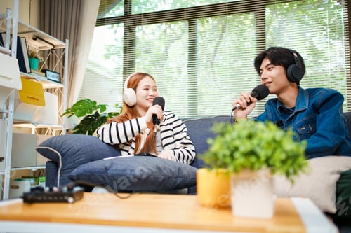 Preview: Two young people recording podcast at home with headphones and microphones