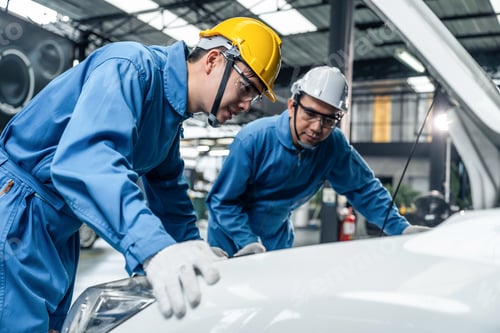 Preview: Asian two automotive mechanic men wear helmet work in mechanics garage.