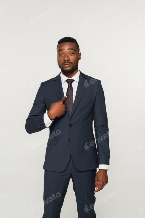 Preview: african american businessman in suit pointing with finger at himself isolated on grey