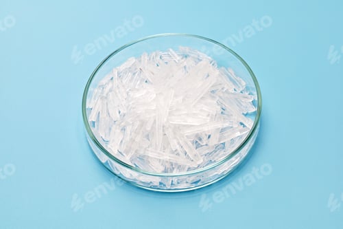 Preview: menthol crystals in a petri dish isolated on sky blue background