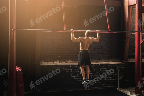 Preview: Strong man doing pull up exercise in the gym