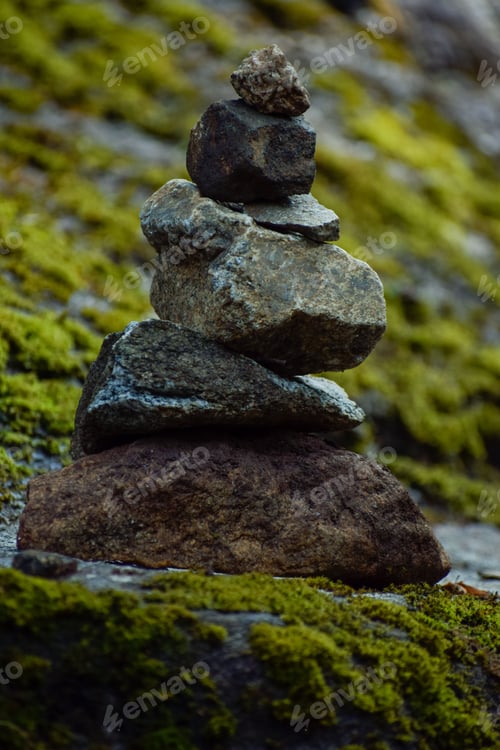 Preview: Vertical shot of stacked rocks on a lush green mossy surface