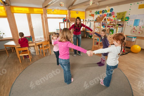 Aperçu: Germany, Nursery, Female nursery teacher and children dancing