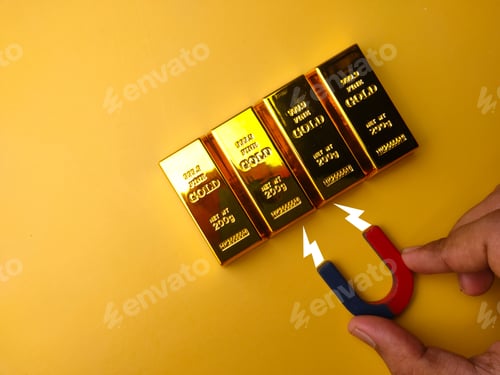 Preview: Hand holding magnet attract the gold bar on a yellow background.