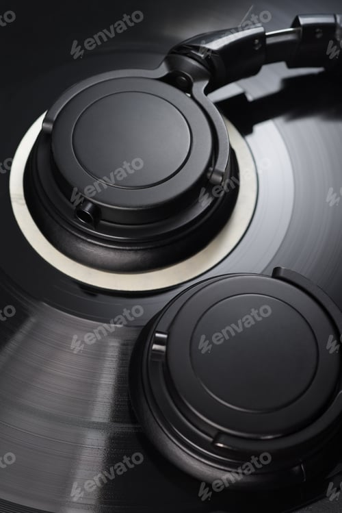 Preview: Vinyl record with black headphones close-up.