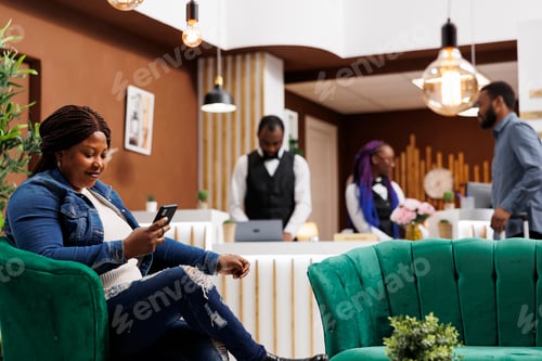 Preview: Woman resting with phone in hotel lobby