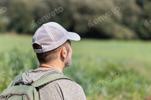 Preview: Man enjoying nature in a green field.