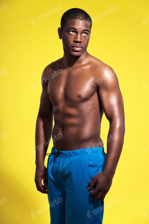 Preview: Athletic Swimmer With Waterdrops. Black Man Wearing Blue Swimming Shorts. Intense Colors. Studio