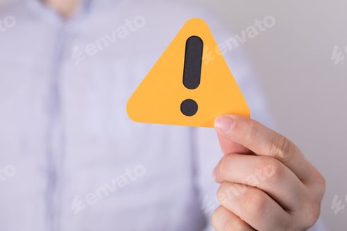 Preview: Man holding a yellow triangular warning sign