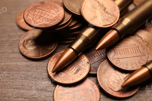 Preview: Firearm cartridges and coins on wooden table, closeup