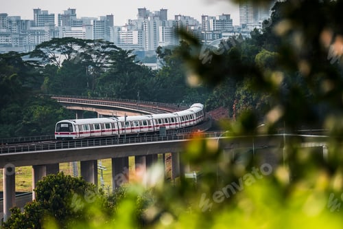 Preview: A Mass Rapid Transit (MRT) train making its way around a bend through the landscape of lush greenery