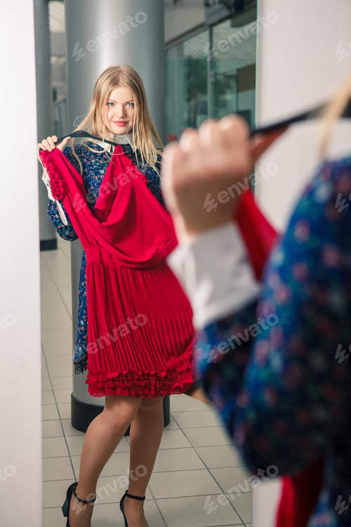 Preview: Woman Trying Red Dress Shopping For Clothing. Beautiful Happy Blonde Smiling Young Shopper Woman