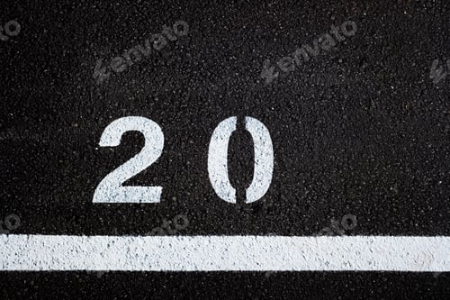 Preview: Number 20, painted on the paved ground of a parking lot with white paint.