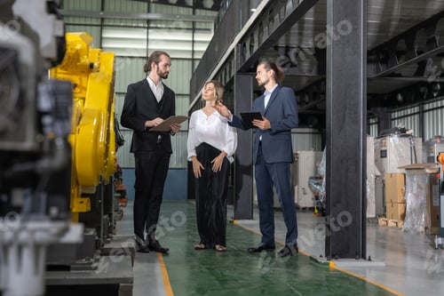 Preview: Businessman with female owner engineer explain assemble robot arms welding at warehouse factory