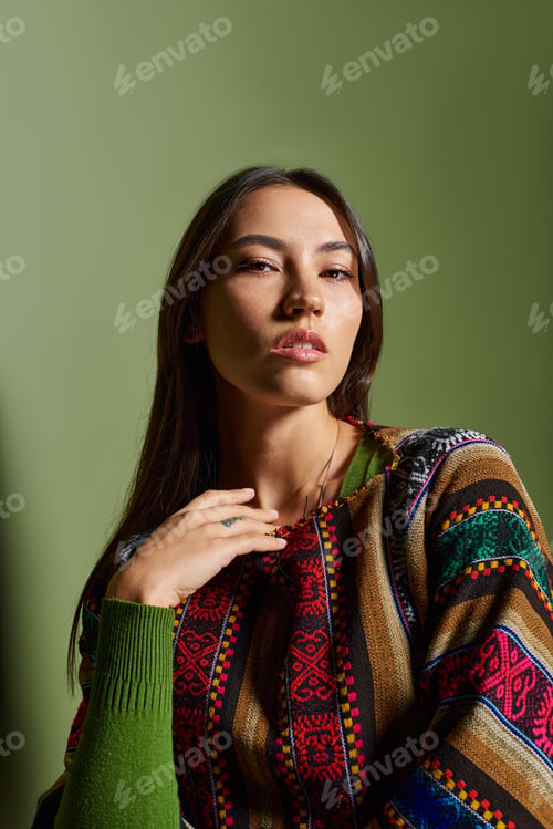 Preview: Captivating beauty of a young brunette woman posing elegantly against a soft green backdrop