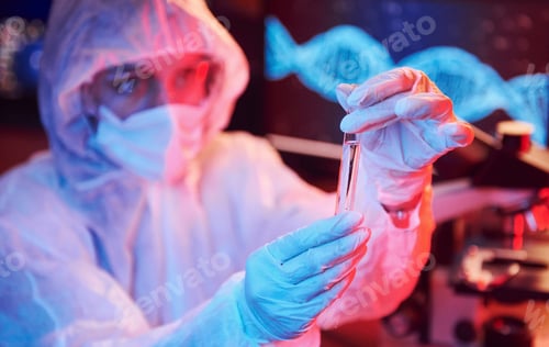 Preview: Nurse in mask and white uniform, holding tube with liquid and sitting in neon lighted laboratory