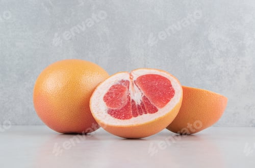 Preview: Ripe sliced grapefruits on stone background