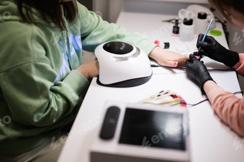 Preview: Manicure master working with female client in beauty salon. Manicurist makes woman nail.