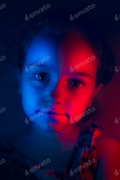 Preview: Vertical closeup shot of a female child under blue and red neon lights