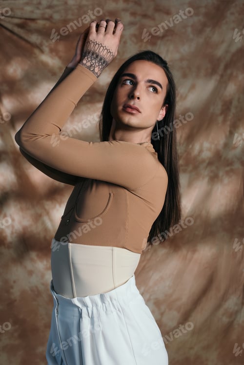 Preview: Brunette nonbinary person in corset posing on abstract brown background