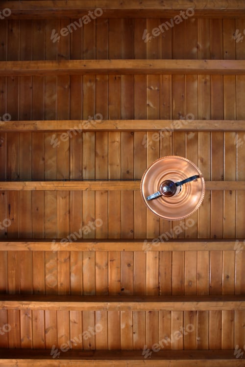 Preview: Low angle shot of a vintage lamp hanging from a wooden ceiling