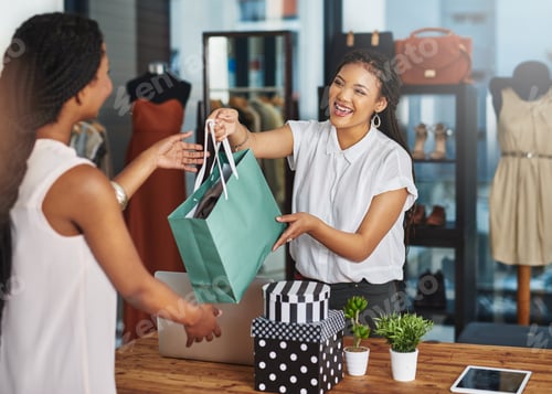 Preview: Cropped shot of a young store owner handing a parcel to a customer over the counter