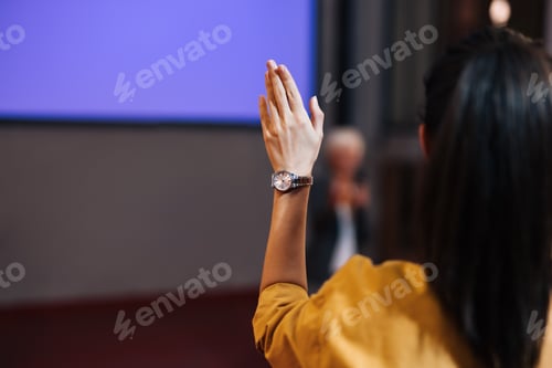Preview: Brunette female from the public, holding a hand, asking for the word.