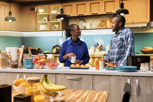 Preview: Smiling adults chatting in the kitchen over fresh roasted coffee cups