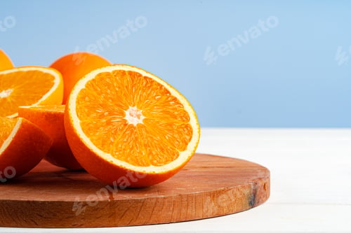 Preview: Cut oranges on wooden board on table