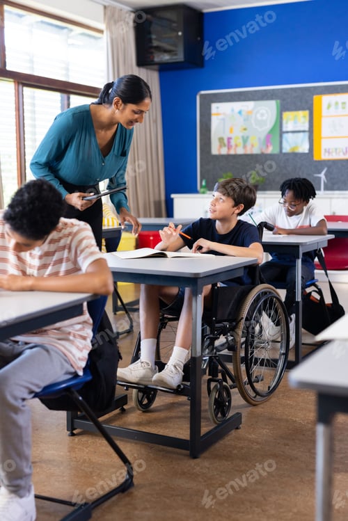 Preview: In school, Indian female teacher assisting student in wheelchair during classroom activity