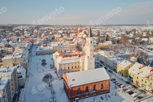 Preview: Snowy town center with church tower rising above buildings in winter