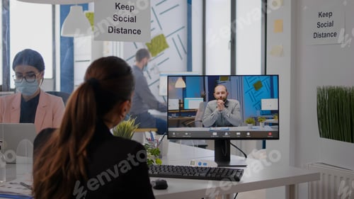 Preview: Back view of business woman with face mask disscusing on videocall conference